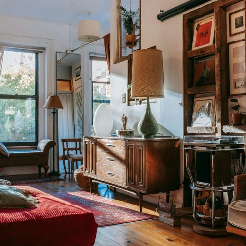 Warm and inviting vintage-style living room with record player, vintage furniture, and sunlight streaming through the window.